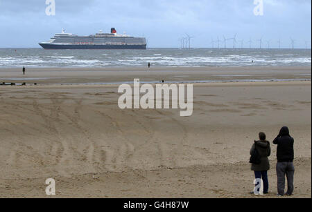 Cunard Passagierschiff Queen Elizabeth auf ihrem Weg vorbei an Antony Gormley's Another Place in Crosby Merseyside. Der Cruise Liner legt im Rahmen des Mersey River Festivals 2011 in Liverpool an. Stockfoto