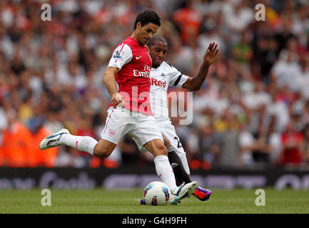 Um Mikel Arteta von Arsenal und Kemy Agustien von Swansea City konkurrieren Der Ball Stockfoto