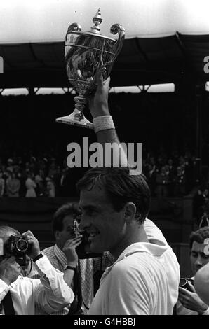 Der australische John Newcombe, der neue Männer-Einzelsieger, hält seine Trophäe hoch, die er von Prinzessin Marina, Präsident des All-England Clubs, erhielt, nachdem er den Deutschen Wilhelm Bungert 6-3; 6-1; 6-1 auf dem Center Court in Wimbledon besiegt hatte. Stockfoto