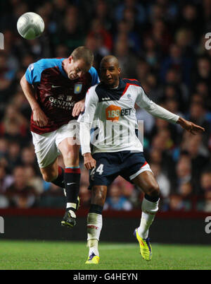 Richard Dunne (links) von Aston Villa schießelt für einen hohen Ball mit David Ngog von Bolton Wanderers während des Carling Cup-Spiels in der dritten Runde im Villa Park, Birmingham. Stockfoto