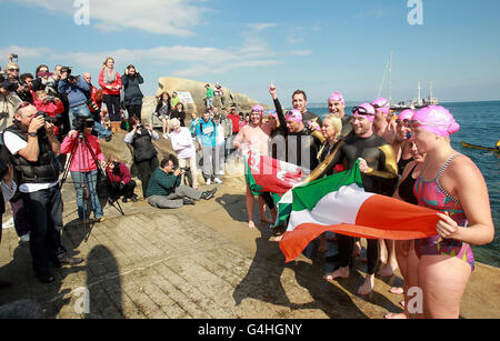 Die Prominenten Ronan Keating (fünfte rechts von der Gruppe), Pamela Stephenson (fünfte links von der Gruppe) und Jenny Frost (zweite links von der Gruppe) kommen am 40 Meter langen Hafen in Dublin an, während sie feiern, dass sie das Schwimmen beendet haben - ein Spendenschwimmen über die Irische See zugunsten von Cancer Research UK. Stockfoto