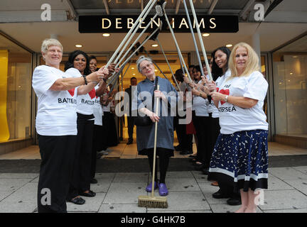 Brenda (Nachname nicht angegeben) vor dem Debenhams-Laden in Battersea im Südwesten Londons, den sie während der Unruhen im August verteidigen kann, wird von Mitarbeitern geehrt. Stockfoto