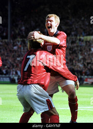 Dieses Bild darf nur im Rahmen eines redaktionellen Features verwendet werden. Der Engländer David Beckham (7) feiert mit seinem Teamkollegen Paul Scholes, nachdem Scholes im Qualifikationsspiel zur EM 2000 in Wembley den zweiten seiner drei Tore gegen Polen erzielte. Stockfoto