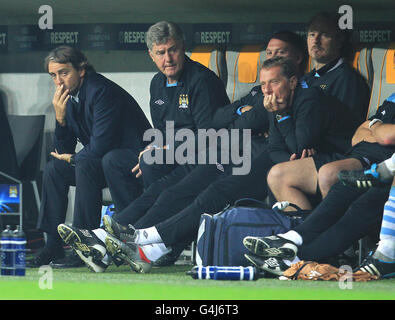 Manchester City Manager Roberto Mancini (links) und seine Mitarbeiter im Hinterzimmer, darunter der stellvertretende Manager Brian Kidd (2. Links), Trainer David Platt und Torwarttrainer Massimo Battara in der Ausgrube Stockfoto