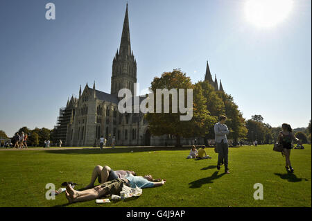 Die Menschen genießen die Sonne in Salisbury Cathedral Close, Salisbury, da sich die Hitzewelle in Teilen Großbritanniens bis in die nächste Woche fortsetzen wird, nach einem Wochenende mit Rekordtemperaturen. Stockfoto