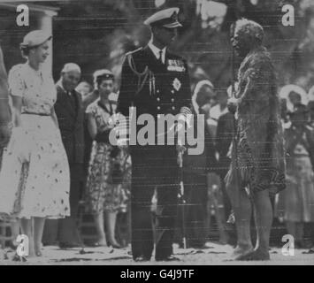 Die Königin und der Herzog von Edinburgh werden vom federgetarntem Maori-Häuptling Henare Toka begrüßt, als sie die Maori und ihre Häupter in Waitangi, Neuseeland, besuchten. Stockfoto