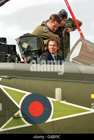 Flugleutnant Paddy Marshal (vorne) und Wing Commander Steve Barnes erklären dem britischen Premierminister Tony Blair, der im Cockpit sitzt, während seines Besuchs bei RAF Lossiemouth in Schottland die Steuerung eines Tornado IDS-Düsenflugzeugs. Stockfoto