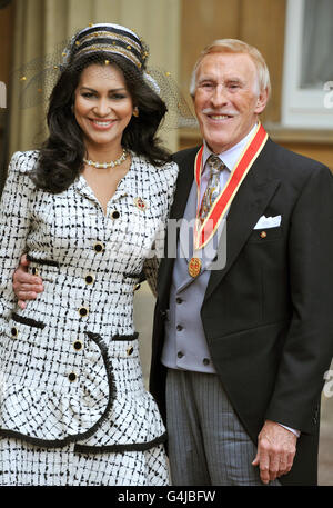 Sir Bruce Forsyth steht mit seiner Frau Wilnelia zusammen, nachdem er von Königin Elizabeth II. Während einer Investiturzeremonie im Buckingham Palace, London, zum Ritter geschlagen wurde. Stockfoto