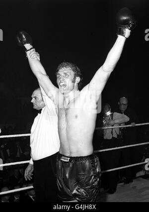 Der Schiedsrichter hebt die Arme des triumphierten Herausforderers Joe Bugner, um seinen Sieg über Henry Cooper in ihrem Titelkampf im Empire Pool in London anzuzeigen. Bugner gewann den Kampf auf Punkte und ist der neue Schwergewichtsmeister von Großbritannien, Europa und dem Commonwealth. Stockfoto