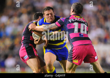 Simon Grix von Warrington Wolves wird von Danny Buderus und Jamie Peacock von Leeds Rhinos während des Engage Super League, Semi Final Matches im Halliwell Jones Stadium, Warrington, angegangen. Stockfoto