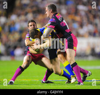 Simon Grix von Warrington Wolves wird von Danny Buderus und Jamie Peacock von Leeds Rhinos während des Engage Super League, Semi Final Matches im Halliwell Jones Stadium, Warrington, angegangen. Stockfoto