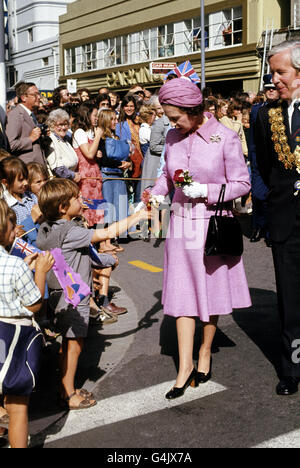 Königin Elizabeth II. Erhält von der 6-jährigen Phillip Neville während eines Spaziergehens in Christchurch, Neuseeland, einen Posy. Stockfoto