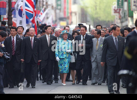 HM Queen Elizabeth II wird von Sicherheitskräften flankiert, während sie am zweiten Tag ihres Besuchs in Südkorea in der Insadong, einer traditionellen Einkaufsstraße, in Seoul spazieren geht. Stockfoto
