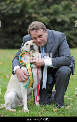 Der konservative Abgeordnete von Tiverton und Honiton Neil Parish und seinem 4-jährigen Labrador Wilberforce, dem Gewinner des Westminster Dog of the Year Wettbewerbs, abgebildet in den Victoria Tower Gardens in London. Stockfoto