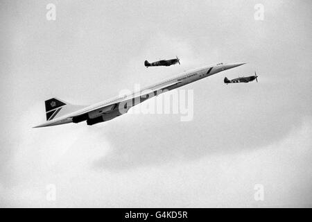 Ein British Airways Concorde wird von zwei Spitfires aus dem Zweiten Weltkrieg beschattet, als es ankommt, um Pässe über die Biggin Hill Air Show zu machen. Stockfoto