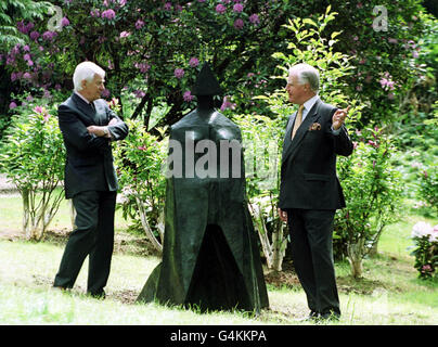 Alan Grieve (links), Vorsitzender der Jerwood Foundation, und Sir Jocelyn Stevens, Vorsitzender von English Heritage, bewundern die Bronzeskulptur „Cloaked Figure 1X“ von Lynn Chadwick, eine von drei modernen Skulpturen im neuen Skulpturenpark am Witley Court in der Nähe von Worcester. Stockfoto