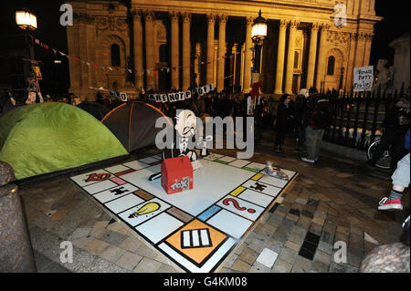 Occupy London Demonstranten vor der St Paul's Cathedral enthüllen eine riesige Monopoltafel, um ihren Campingplatz zu besetzen. Stockfoto