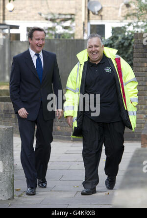 Premierminister David Cameron besucht einen Wohnblock in Hammersmith, wo Wandisolierung eingebaut wird. Cameron räumte ein, dass die Regierung "härter und schneller" arbeiten müsse, um die Energiekosten heute vor einem Gipfel zu senken. Stockfoto