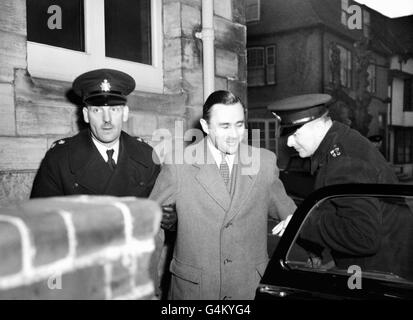 John George Haigh wird beim Horsham-Amtsgericht Sussex unter Polizeieskorte geführt, nachdem er wegen des Mordes an Frau Olive Durand-Deacon, einem der Opfer der so genannten „Morde an saurem Bad“, in Untersuchungshaft genommen wurde. Haigh wurde später für seine Verbrechen hingerichtet. Stockfoto