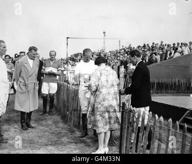 Königin Elizabeth II. Überreicht die Trophäe an den Herzog von Edinburgh, nachdem er das Windsor Park Polo-Team zum Sieg über Casarejo auf Smith's Lawn, Windsor, geführt hatte. Stockfoto