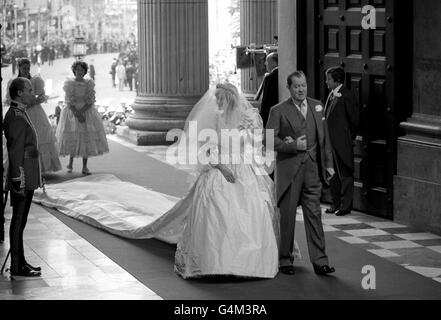 Lady Diana Spencer kommt mit ihrem Vater, Earl Spencer, zur Hochzeit mit dem Prinzen von Wales in der St. Paul's Cathedral in London an. Lady Spencer trägt ein Hochzeitskleid mit einem 25 Fuß langen abnehmbaren Zug, entworfen von Elizabeth und David Emanuel. *Ihr Schleier aus elfenbeinfarbenem Seidentüll, der mit Tausenden von winzigen, handbestickten Perlmutt-Pailletten übersät ist, wird von der Diamantentiara der Spencer Family gehalten. Brautjungfern - India Hicks (rechts) und Sarah Armstrong-Jones. Stockfoto