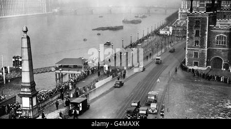 Tausende von Menschen ziehen langsam entlang des Südufers der Themse gegenüber den Houses of Parliament, um König George VI. Bei seiner im Staat liegenden Lage in der Westminster Hall zu ehren. Stockfoto