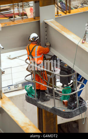 Bauarbeiter in einem Hebezeug Installation Stahlträger an Eastern Schalterhalle der Crossrail, Farringdon Station, London Stockfoto