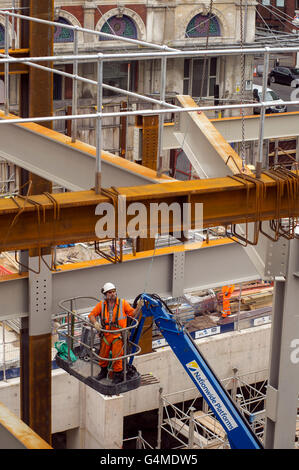 Bauarbeiter in einem Hebezeug Installation Stahlträger an Eastern Schalterhalle der Crossrail, Farringdon Station, London Stockfoto