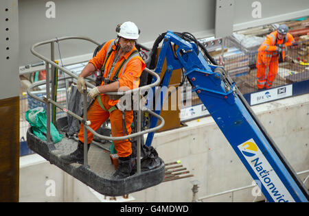 Bauarbeiter in einem Hebezeug Installation Stahlträger an Eastern Schalterhalle der Crossrail, Farringdon Station, London Stockfoto