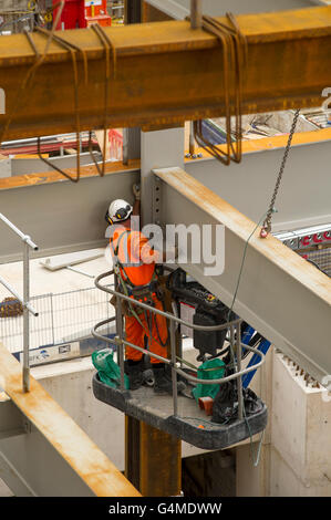 Bauarbeiter in einem Hebezeug Installation Stahlträger an Eastern Schalterhalle der Crossrail, Farringdon Station, London Stockfoto