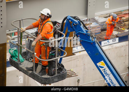 Bauarbeiter in einem Hebezeug Installation Stahlträger an Eastern Schalterhalle der Crossrail, Farringdon Station, London Stockfoto