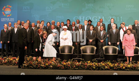 Die australische Premierministerin Julia Gillard folgt Königin Elizabeth II., als sie während der Eröffnungszeremonie des Commonwealth Heads of Government Meetings 2011 in Perth, Westaustralien, Platz für ein offizielles Gruppenfoto nimmt. Stockfoto