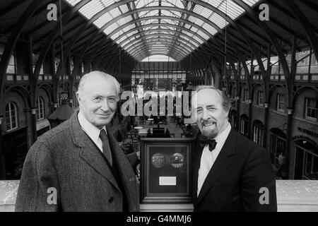 Lord Duncan-Sandys (l.), Präsident von Europa Nostra, nachdem er Sir Horace Cutler (r.), dem Vorsitzenden des Greater London council, die Europa-Nostra-Medaille in Covent Garden überreicht hatte. Die Medaille wurde dem GLC für die Restaurierung des ehemaligen zentralen Marktgebäudes (Hintergrund) verliehen. Die Auszeichnung, entworfen und gespendet von Franklin Mint of London, besteht aus einer speziell geprägten Medaille in einem Mahagoni-Rahmen mit einer Plakette mit einer Beschreibung des Projekts montiert. Stockfoto