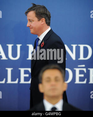 Der französische Präsident Nicolas Sarkozy steht im Vordergrund, als der britische Premierminister David Cameron beim G20-Gipfel in Cannes, Frankreich, eintrifft. Stockfoto