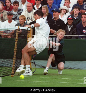 Keine Kommerzielle Nutzung. Die Briten Miles Maclagan stoßen bei seinem Spiel mit dem deutschen Boris Becker in Wimbledon auf ein Ballgirl. Stockfoto