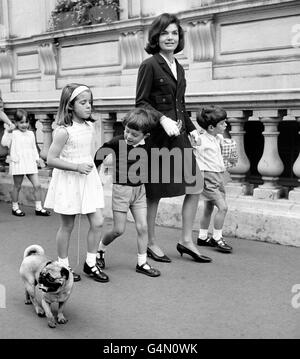 Frau Jackie Kennedy, die Frau des verstorbenen amerikanischen Präsidenten John F. Kennedy, mit ihrem Sohn John Jr (L) und ihrer Tochter Caroline (R) mit ihrem Cousin Anthony (Mitte rechts) in London zur Einweihung des Denkmals für den verstorbenen John Kennedy in Runnymede in der Nähe von windsor. Stockfoto