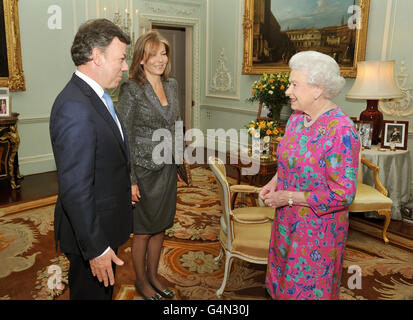 Königin Elizabeth II. Spricht mit dem Präsidenten von Kolumbien, Juan Manuel Santos, während seine Frau Maria von seiner Seite aus zuschaut, wo sie sich bei seinem kurzen Besuch im Vereinigten Königreich im Buckingham Palace im Zentrum von London in einer privaten Audienz trafen. Stockfoto