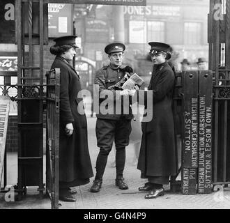 Weibliche Ticketsammler checken das Ticket eines britischen Soldaten in Victoria Station, London, während des Ersten Weltkriegs. Im Laufe des Krieges und der Einberufung oder Freiwilligentätigkeit von Männern in die Streitkräfte spielten Frauen eine immer wichtigere Rolle bei der Aufrechterhaltung von Transport-, Heim- und Industriedienstleistungen in ganz Großbritannien. Stockfoto