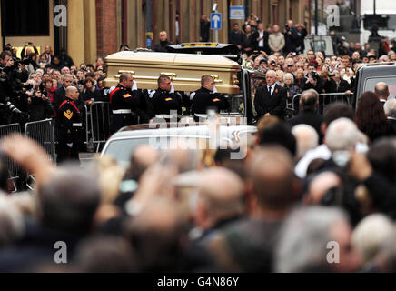 Der Sarg von Sir Jimmy Savile wird aus der römisch-katholischen St. Anne's Cathedral in Leeds getragen, wo seine Beerdigung stattfand. Stockfoto