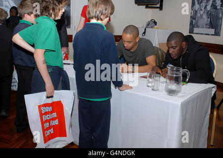 Show Racism der Red Card-Schirmherr und ehemalige Fußballspieler Trevor Benjamin und Nottingham Forest's Dexter Blackstock (Mitte) geben Autogramme für Schulkinder Stockfoto