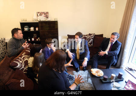 Premierminister David Cameron und der stellvertretende Premierminister Nick Clegg treffen Jason und Laura White (Familie neben dem stellvertretenden Premierminister) und ihre Kinder Josh und Katie, Und Debbie Purves (im Vordergrund), eine Familie, die vor kurzem in einem Haus in Boxgrove Gardens in Guildford als £400 Millionen-Fonds für den Startschuss für den Hausbau eingezogen ist, wird heute als Teil der Regierungspläne zur Lösung der britischen Wohnungskrise bekannt gegeben. Stockfoto