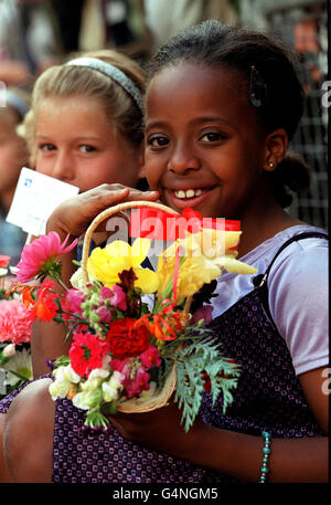 Ein Kind, das einen Blumenkorb für die Königin Mutter an ihrem 99. Geburtstag hält. Stockfoto