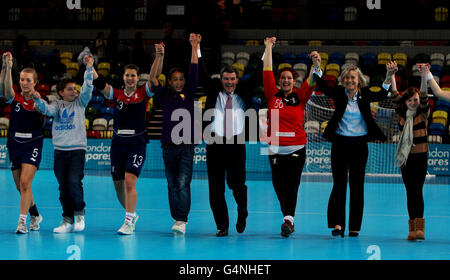 Hugh Robertson, Minister für Sport und Olympische Spiele (Mitte) nach dem Ende des GB gegen Angola-Spiels mit Torhüterin Marie Gebron (3. Rechts) und Nina Hegland (Nr. 5), und Yvonne Leuhold (Nr. 13) während des London Handball Cup und 2012 Testevent im Olympic Park, London. Stockfoto