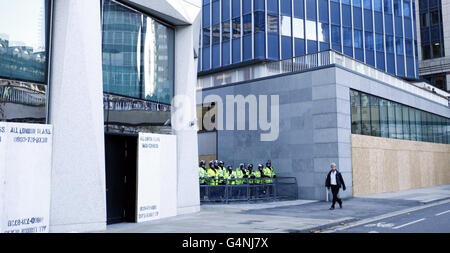 Studentengebühren protestieren. Ein Mann kommt während des letzten studentengeldes-marsches in London Wall, London, an der Polizei vorbei, die in Krawallkleidung gekleidet ist. Stockfoto