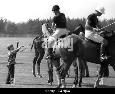 Der Herzog von Edinburgh erhält von seinem Sohn Prinz Edward, 7, während eines Polo-Spiels im Windsor Great Park einen Polostab. Stockfoto