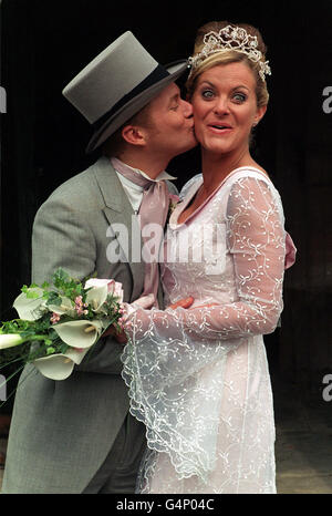 Maxine (Tracy Shaw) von Coronation Street wird von ihrem Partner Ashley (Steve Arnold) nach den Dreharbeiten zur Hochzeit in der St. Mary's Church, Prestwich, in Manchester, geküsst. Stockfoto