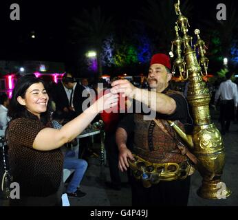 Damaskus, Syrien. 18. Juni 2016. Abu Salim, ein traditionelles Tamarinde Saft Verkäufer mit einer Laterne-Stil Messing Kühler, gibt ein Kunde ein Glas Tamarinde in Altstadt von Damaskus, die Hauptstadt von Syrien, am 18. Juni 2016. Abu Salim sagte, dass seine traditionellen Job erbte er von seinen Vorfahren, fügte hinzu, dass seine Arbeit bei den Fastenmonat Ramadan, blüht wie Tamarindensaft von Menschen während des Fastenmonats begünstigt wird. © Ammar/Xinhua/Alamy Live-Nachrichten Stockfoto