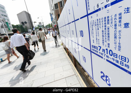 Fußgänger gehen vorbei an einem Plakat Bord speziell für Wahl-anzeigen bereit, Kandidaten Plakate für Julys Oberhaus Wahlen auf dem Display in Tokios Straßen am 20. Juni 2016, Japan errichtet. Im Vorfeld des 10. Juli Umfrage Kandidaten gehen durch die Straßen, das Aufstellen von Plakaten, hielt Reden und halten Kundgebungen, um ihre Politik zu präsentieren. In diesem Jahr Zielen die politischen Parteien Jungwähler, im Alter von 18 und 19 jährigen, die zum ersten Mal abstimmen dürfen. © Rodrigo Reyes Marin/AFLO/Alamy Live-Nachrichten Stockfoto