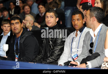 Christiano Ronaldo (links) und Luis Nani (zweite rechts) sehen sich an, als der Franzose Jo-Wilfried Tsonga beim Finale der Barclays ATP World Tour Finals in der O2 Arena in London gegen den Schweizer Roger Federer antritt. Stockfoto