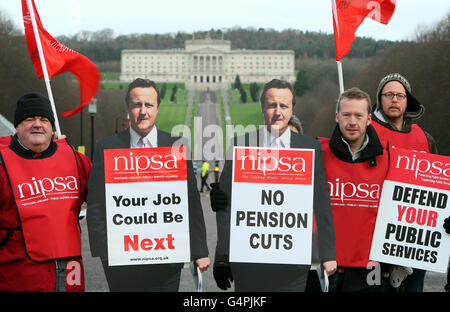 Streikende Arbeiter, lebensgroße Bilder von Premierminister David Cameron vor Stormont Castle. Stockfoto